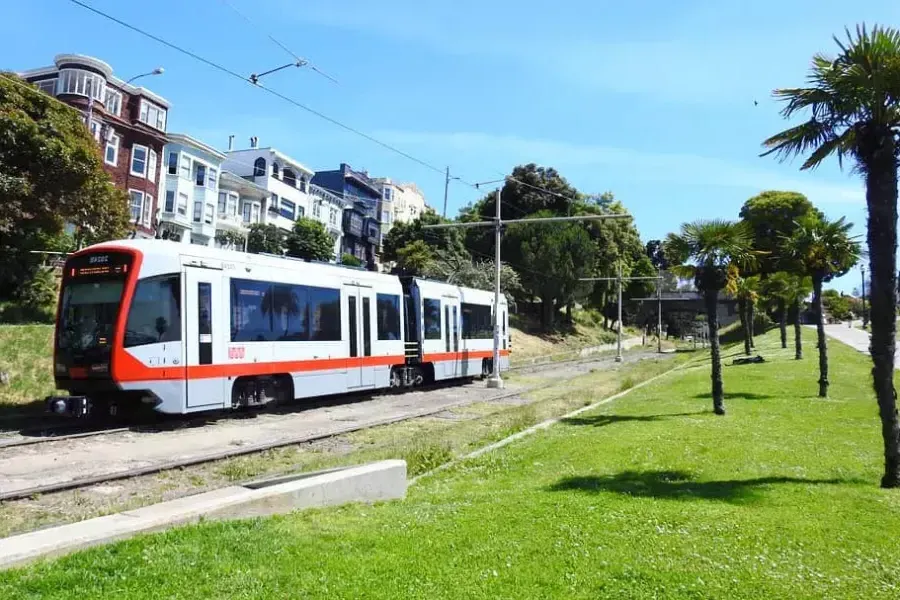 MUNI 旅客列車がサンフランシスコの線路に沿って走っています。